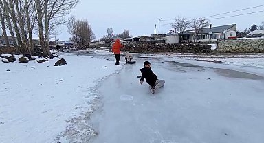 Buz tutan derede kızakla kayıp gönüllerince eğlendiler