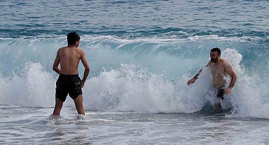 Yüksek kesimlerinde kar etkili olan Antalya'nın sahilinde deniz keyfi