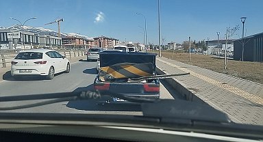 Karayolu işaret levhasını otomobil ile taşıdı