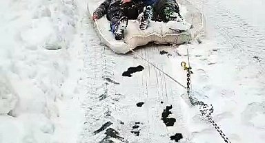 Traktörün arkasına bağladıkları yatakla karda kaydılar