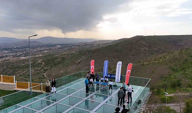 Cam teras üzerinde masa tenisi karşılaşması, renkli görüntüler oluşturdu