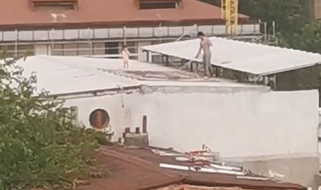 Çocukla birlikte çatıda halı yıkayan vatandaş kamerada