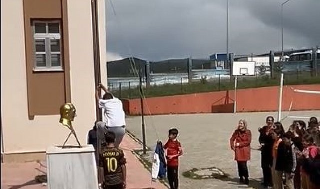 Okul önünde direğe dolanan bayrağı tırmanarak çözdü