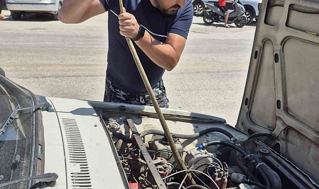Aracın motoruna giren yılanı elindeki sopayla çıkardı