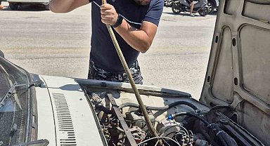 Aracın motoruna giren yılanı elindeki sopayla çıkardı