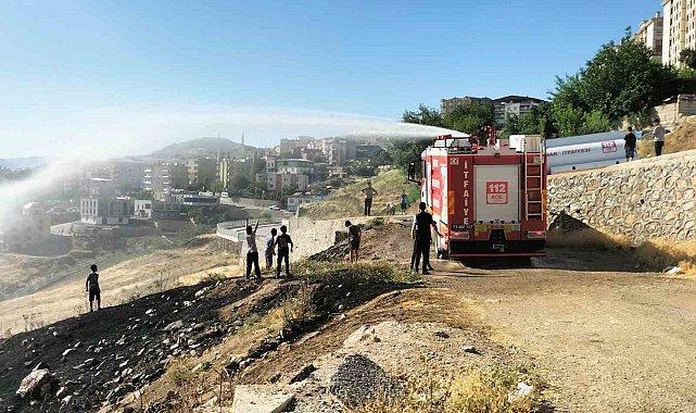 İtfaiyeciler yangın söndürme derdinde, çocuklar serinlemenin keyfinde