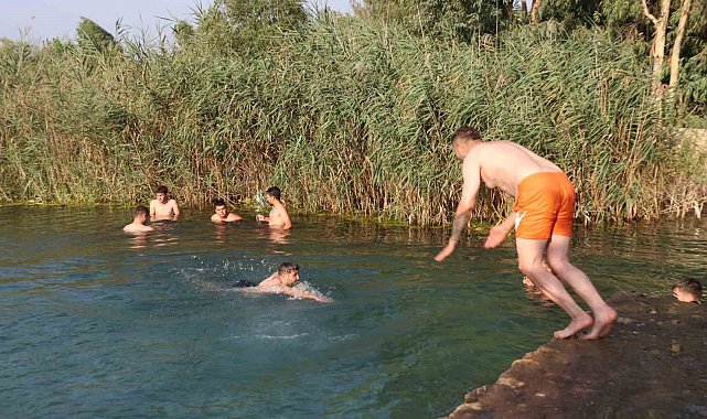 Adana'da gençler bunaltan sıcakta gölette serinledi