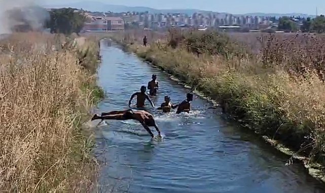 Çifte tehlike: Yangına rağmen su kanalındaki oyunlarını bozmadılar