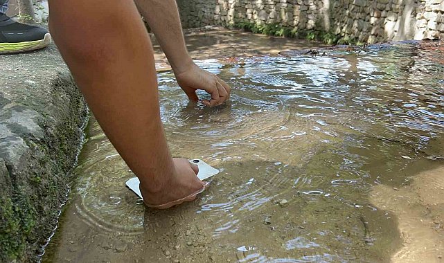 Sıcaklığın 45 dereceyi bulmasıyla telefonlarını suda soğuttular