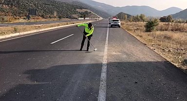 Trafik polisi cam kırıkları ve taş dökülen yolu fırçayla temizledi