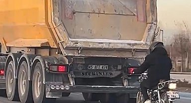 Seyir halindeki tırın peşinde motosikletli tehlikeli yolculuk