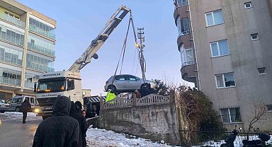Buzlanan yolda kayan otomobil apartmanın bahçesine düştü