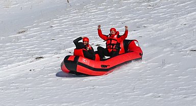 Karla kaplı dağdan donmuş gölete botla kaydılar