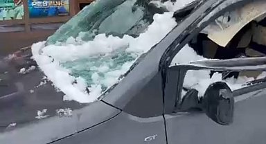 Park halindeki aracın üzerine çatıdan kar kütlesi düştü