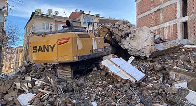Ağır hasarlı binanın enkazı iş makinesinin üstüne yıkıldı