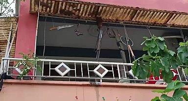 Balkonda silah, balta ve kılıç sergileyen şahıs hayrete düşürdü