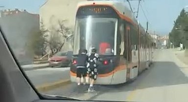 Tramvayın arkasına tutunan patenli çocukların tehlikeli yolculuğu