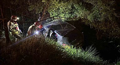 Dereye uçan otomobilde sıkışan sürücüyü itfaiye ekipleri kurtardı