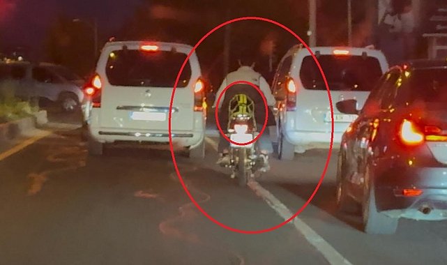 Motosiklet sürücüsü trafikte kaskı başına takması yerine arkasına bağladı