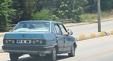 Ayaklarını camdan dışarı çıkartan yolcu trafiği riske attı