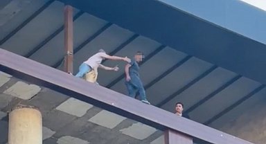 Binanın en üst katında intihara kalkışan şahsı son anda kurtardı: O anlar kamerada