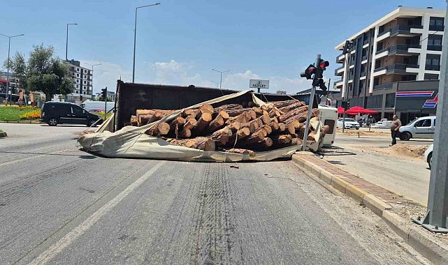 Kamyon kavşağa girerken devrildi, tomruklar yola savruldu