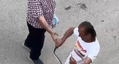 Paniğe sebep olan yılanı eliyle yakaladı