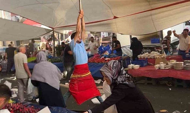 Kuvvetli rüzgarda pazarcı branda direğini bırakmadı, metrelerce havaya yükseldi