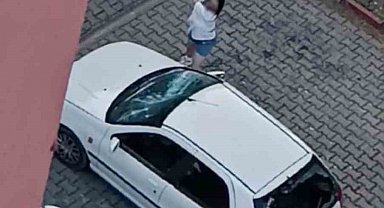 Park halindeki otomobilin camlarını kıran kadın kamerada