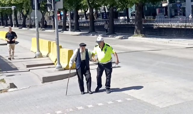 Trafik polisinin yürümekte zorlanan yaşlı adama yardımı yürekleri ısıttı