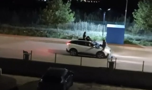 İki kadının seyir halindeki otomobilin üstünde tehlikeli yolculuğu kamerada
