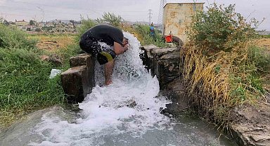 Kavurucu sıcakta elbisesini bile çıkarmadan buz gibi sondaj suyunda serinledi