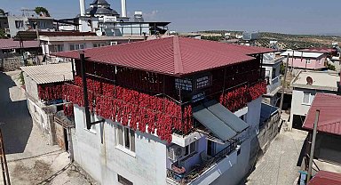 Kavurucu sıcakta tek tek ipe dizilen dolmalık acı biberler, mahalledeki balkonları kırmızıya bürüdü