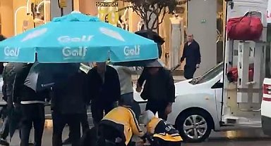 Yolun karşısına geçerken otomobil çarptı: Vatandaşlar yaralıya şemsiye tuttu