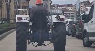 Bolu'da trafikte ilginç görüntü: Başına duba geçirip traktör sürdü