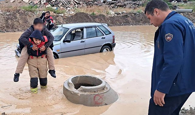 İtfaiyeci, göle dönen yolda mahsur kalan çocuğu sırtında taşıyarak kurtardı