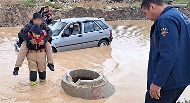 İtfaiyeci, göle dönen yolda mahsur kalan çocuğu sırtında taşıyarak kurtardı