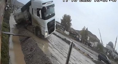 Yol vermek isterken kanala devrildi: Taş yüklü tırın kazası kamerada